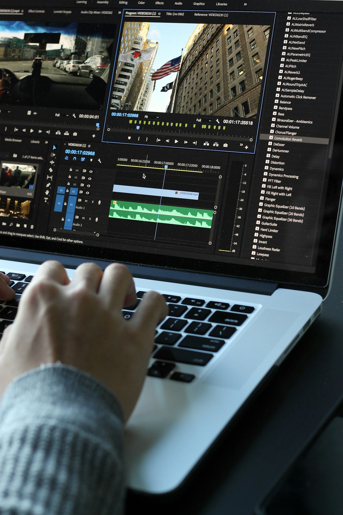 Video editing software open on a laptop with a timeline and audio waveform