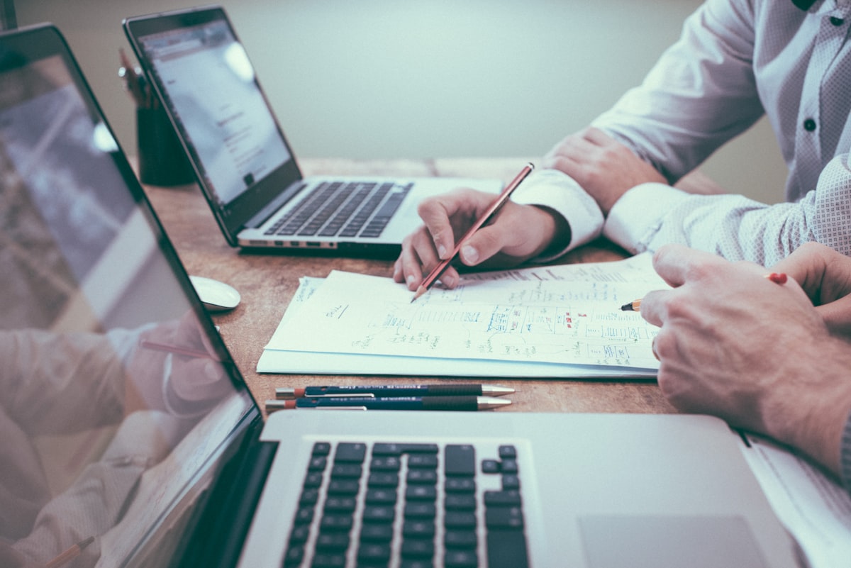 A business professional collaborating over documents and a laptop in a modern office
