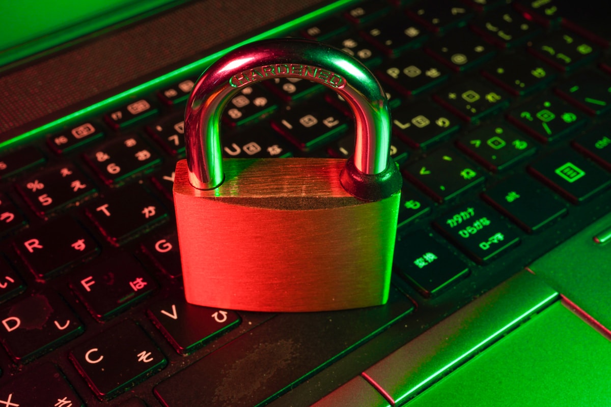 Padlock resting on a laptop keyboard lit in red and green
