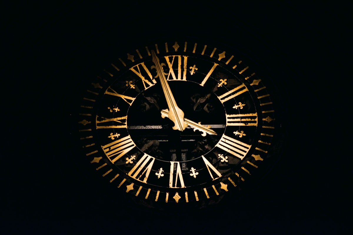An ornate gold clock face against a dark background